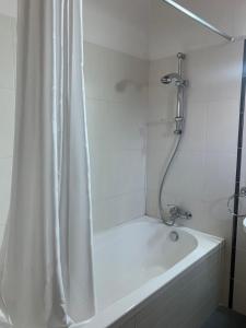 Villa for rent in MILIOU close to Lachi & Peyia في ميليو: حمام مع حوض استحمام مع ستارة دش