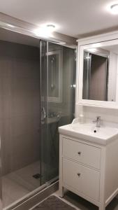 a bathroom with a shower and a sink and a mirror at City View Apartment in Mytilini