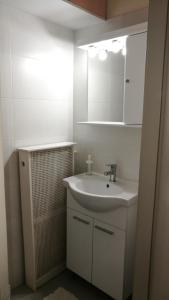 Baño blanco con lavabo y espejo en City View Apartment, en Mytilini