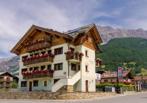 a building with flowers on the balconies on a street at Residence Pedranzini in Bormio