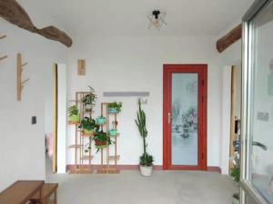 una stanza con una porta rossa e piante sul muro di Air Cloud Guesthouse a Huailai