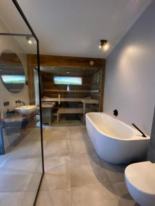 ein Badezimmer mit Badewanne, Toilette und Waschbecken in der Unterkunft Welcome in - Lepelblad 44, Nieuwvliet in Nieuwvliet + 23 Fotos