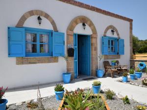uma casa com persianas azuis e um pátio em Villa Pavlina Gennadi em Gennadi