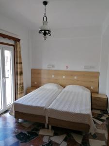 sypialnia z łóżkiem i żyrandolem w obiekcie Lefteris Rooms w mieście Kokkari