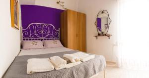 a bedroom with a bed with a purple headboard at Zoli house in Pefkochori