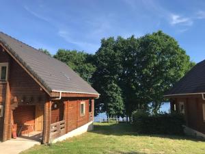 a couple of buildings with trees in the background at Au bord du lac IV in Montigny-en-Morvan
