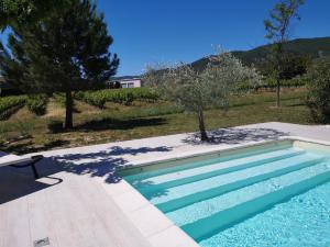 een zwembad voor een tuin met bomen bij Auberge de l Helvie chez Coco & Ricou in Valvignères