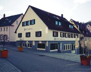 a large white building on a cobblestone street at Arthotel Nagold in Nagold