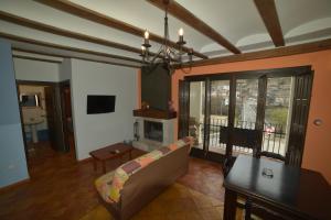 a living room with a couch and a fireplace at Apartamentos Rurales Puerta del Sol in Alcalá del Júcar