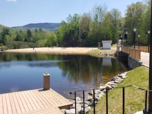 a body of water with a dock and a beach at Town Square Condominiums in Waterville Valley