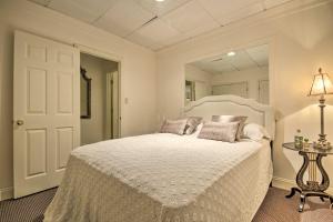 une chambre avec un grand lit blanc avec un miroir dans l'établissement Cozy Cockeysville Retreat with Furnished Deck!, à Cockeysville