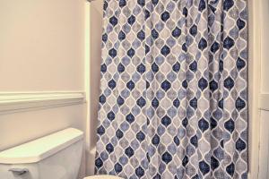 La salle de bains est pourvue d'un rideau de douche noir et blanc. dans l'établissement Cozy Cockeysville Retreat with Furnished Deck!, à Cockeysville 17 autres photos