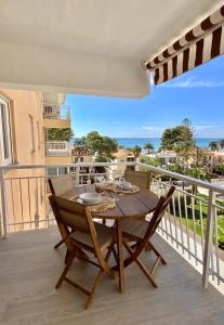 a wooden table on a balcony with a view of the ocean at Hogar en Benicasim in Benicàssim