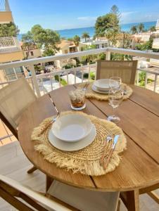 a wooden table with plates and glasses on a balcony at Hogar en Benicasim in Benicàssim