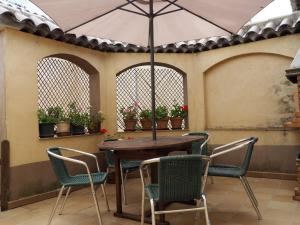 a table and chairs with an umbrella on a patio at Casa De Nohales in Nohales