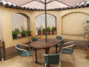 a table and chairs with an umbrella on a patio at Casa De Nohales in Nohales