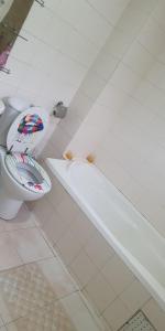 a bathroom with a toilet and a bath tub at Appart Sly Abidjan in Cocody