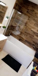 a white bath tub in a bathroom with a wooden floor at Le cosy de sarah in Bordeaux-Saint-Clair