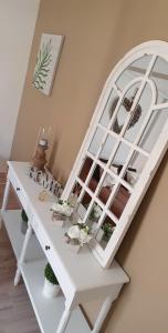 a white desk with a window and flowers on it at Le cosy de sarah in Bordeaux-Saint-Clair