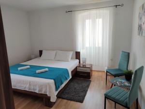 sypialnia z łóżkiem i dwoma niebieskimi krzesłami w obiekcie Apartman Josip w mieście Garica