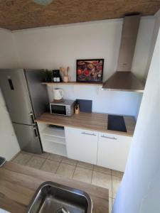 eine Küche mit einem Kühlschrank aus Edelstahl und einer Spüle in der Unterkunft Apartman Josip in Garica