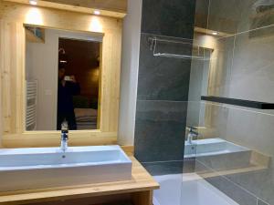 a person taking a picture of a bathroom with a sink at La Maison De Marie in Le Monêtier-les-Bains