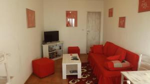 a living room with a red couch and a tv at Luštica Apartments in Luštica