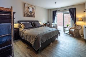 - une chambre avec un grand lit et une fenêtre dans l'établissement Herberg Binnen, à Egmond-Binnen