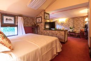 a hotel room with a bed and a television at Villa Abbazia Relais & Chateaux in Follina