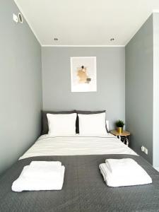 Pokoje Gościnne Przy Molo في غدينيا: غرفة نوم مع سرير مع وسادتين بيضاء