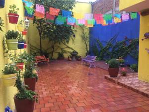 a courtyard with potted plants and a flag at Hostal Tlaquepaque in Guadalajara