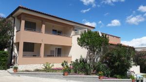 a large building with trees in front of it at Rooms Nadia3 in Baška