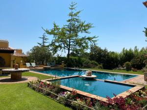 a swimming pool with a fountain in a yard at Quinta das Pedras - Small Luxury Guesthouse in Sintra