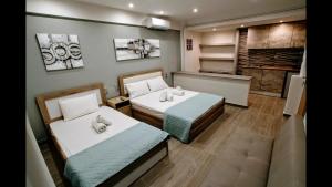 Habitación pequeña con 2 camas y cocina en LDG Rooms, en Olympiakí Aktí