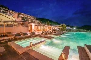 a pool at a hotel at night at Isola Verde in Syvota