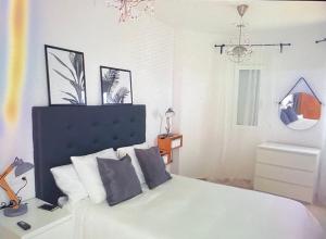 Schlafzimmer mit einem weißen Bett und einem Spiegel in der Unterkunft Villaterramarina in Finestrat