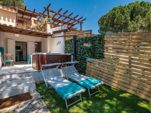 un patio con 2 sillas y una valla en Sardinia SPA Apartment, en Geremèas