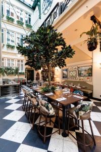 a table with a tree in the middle of a restaurant at Elite Plaza Hotel in Gothenburg