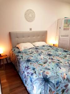 1 dormitorio con 1 cama con colcha de flores en Sea, Sand & Sun Beach Flat, en Albufeira