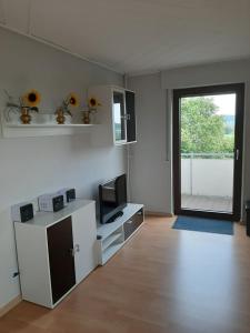 una sala de estar vacía con TV y ventana en Familienfreundliche Ferienwohnung auf dem Lande Monteur Wohnung, en Hessisch Oldendorf