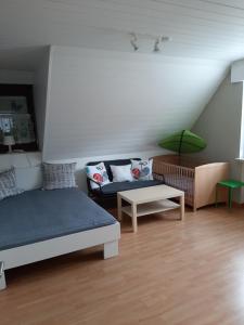 een woonkamer met 2 bedden en een bank bij Familienfreundliche Ferienwohnung auf dem Lande Monteur Wohnung in Hessisch Oldendorf