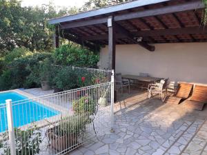 un patio con tavolo e sedie accanto alla piscina di La Bergerie a Lagarrigue