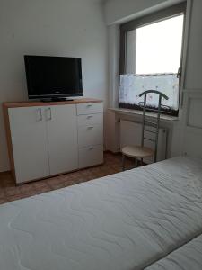 1 dormitorio con 1 cama, TV y silla en Familienfreundliche Ferienwohnung auf dem Lande Monteur Wohnung, en Hessisch Oldendorf