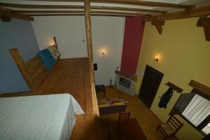 a bedroom with a bed and a living room with a fireplace at Apartamentos Rurales Puerta del Sol in Alcalá del Júcar