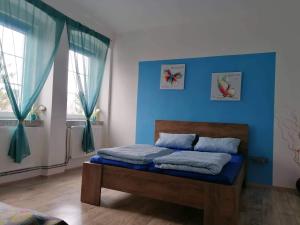 a bedroom with a bed with a blue wall at Olsinky in Ústí nad Labem
