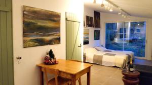 een slaapkamer met een bed en een tafel in een kamer bij Beautiful studio surrounded by nature in Lanet