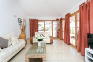 uma sala de estar com um sofá e uma mesa em CASA AMARILLA sunny holiday home with heated pool em San Miguel de Abona