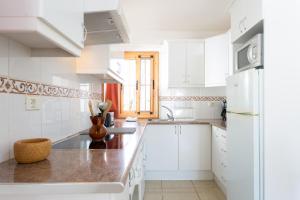 uma cozinha com armários brancos e uma bancada em CASA AMARILLA sunny holiday home with heated pool em San Miguel de Abona