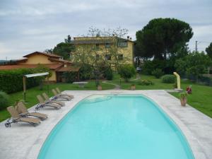 una piscina con sillas y una casa en el fondo en Villa Casa Gemelli, en Capolona