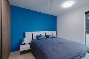 een blauwe slaapkamer met een bed met een blauwe muur bij Perle bleue résidence in Saint-Leu